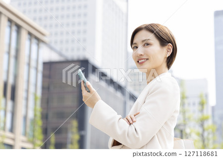 Business portrait of a woman looking at a smartphone 127118681