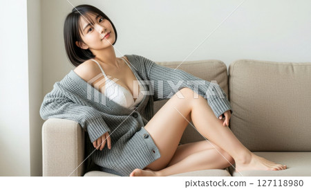A Japanese female model in underwear smiling on the sofa 127118980