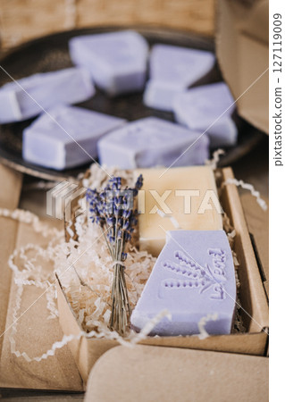 Handmade lavender soaps packed in kraft boxes with shredded filler in a cozy workspace. Home-based business, handmade skincare, small batch production, eco-friendly packaging Handmade lavender soaps packed in kraft boxes with shredded filler in a cozy workspace. Home-based business, handmade skincare, small batch production, eco-friendly packaging 127119009