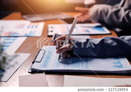 Group of confident business people point to graphs and charts to analyze market data, balance sheet, account, net profit to plan new sales strategies to increase production capacity. Group of confident business people point to graphs and charts to analyze market data, balance sheet, account, net profit to plan new sales strategies to increase production capacity. 127119954