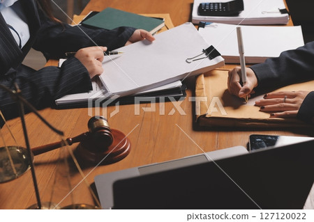 Attractive young lawyer in office Business woman and lawyers discussing contract papers with brass scale on wooden desk in office. Law, legal services, advice, Justice and real estate concept. Attractive young lawyer in office Business woman and lawyers discussing contract papers with brass scale on wooden desk in office. Law, legal services, advice, Justice and real estate concept. 127120022