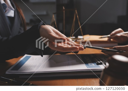 Attractive young lawyer in office Business woman and lawyers discussing contract papers with brass scale on wooden desk in office. Law, legal services, advice, Justice and real estate concept. Attractive young lawyer in office Business woman and lawyers discussing contract papers with brass scale on wooden desk in office. Law, legal services, advice, Justice and real estate concept. 127120030