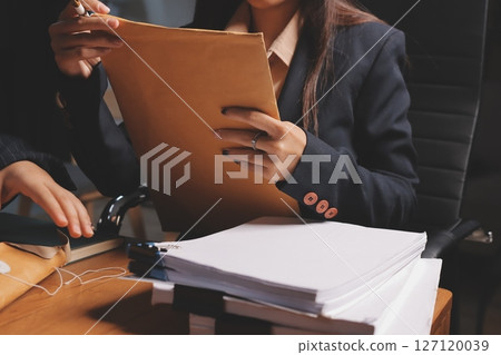 Attractive young lawyer in office Business woman and lawyers discussing contract papers with brass scale on wooden desk in office. Law, legal services, advice, Justice and real estate concept. Attractive young lawyer in office Business woman and lawyers discussing contract papers with brass scale on wooden desk in office. Law, legal services, advice, Justice and real estate concept. 127120039
