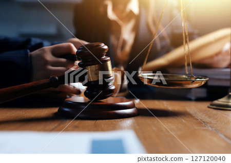 Attractive young lawyer in office Business woman and lawyers discussing contract papers with brass scale on wooden desk in office. Law, legal services, advice, Justice and real estate concept. Attractive young lawyer in office Business woman and lawyers discussing contract papers with brass scale on wooden desk in office. Law, legal services, advice, Justice and real estate concept. 127120040