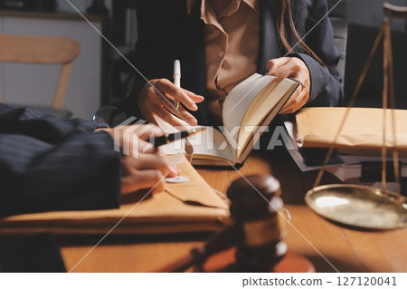 Attractive young lawyer in office Business woman and lawyers discussing contract papers with brass scale on wooden desk in office. Law, legal services, advice, Justice and real estate concept. Attractive young lawyer in office Business woman and lawyers discussing contract papers with brass scale on wooden desk in office. Law, legal services, advice, Justice and real estate concept. 127120041