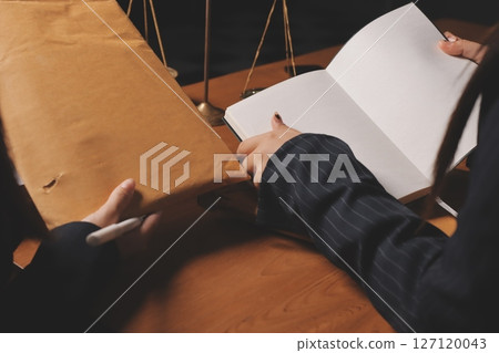 Attractive young lawyer in office Business woman and lawyers discussing contract papers with brass scale on wooden desk in office. Law, legal services, advice, Justice and real estate concept. 127120043