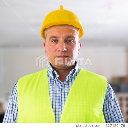 Waist-up portrait of man builder in coverall and helmet 127120476