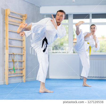 Adult man and young woman training karate technique Adult man and young woman training karate technique 127120538