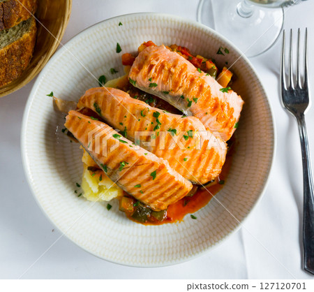 Tasty steak of grilled salmon in sauce with pepper and lemon on plate Tasty steak of grilled salmon in sauce with pepper and lemon on plate 127120701