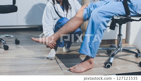 Physical therapist teaching a patient how to do exercises for his knee pain Physical therapist teaching a patient how to do exercises for his knee pain 127121535