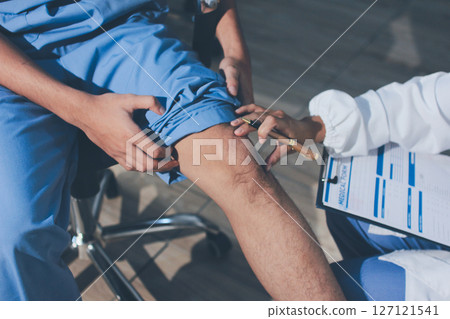 Physical therapist teaching a patient how to do exercises for his knee pain Physical therapist teaching a patient how to do exercises for his knee pain 127121541