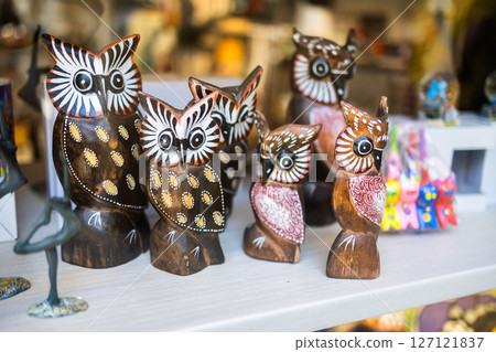 Wooden owlsouvenirs displayed in shop. Handcrafted art and cultural gifts concept. 127121837