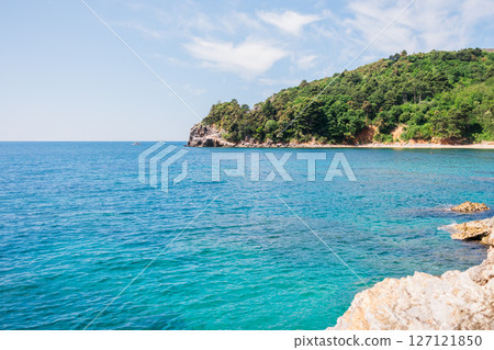 Rocky coastline meets vibrant turquoise sea. Coastal scenery, summer nature, and serene outdoor exploration. Rocky coastline meets vibrant turquoise sea. Coastal scenery, summer nature, and serene outdoor exploration. 127121850