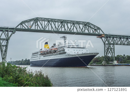 A cruise ship sails under the Hochdonn High Bridge on the Kiel Canal, Schleswig-Holstein, Germany  127121891