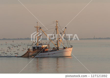 Trawler fishing with a trawl net at dusk in the North Sea, Germany 127121892