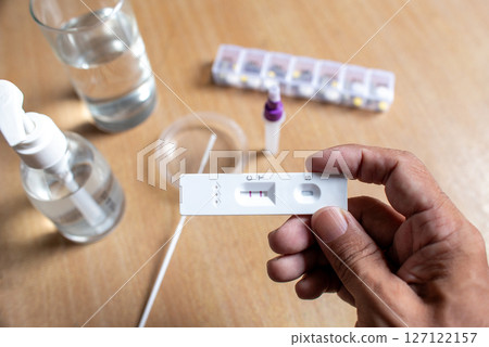 Close-up of hands holding a COVID-19 positive rapid antigen test kit Close-up of hands holding a COVID-19 positive rapid antigen test kit 127122157