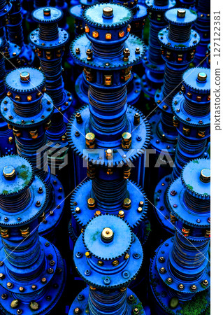 A bunch of blue gears that are sitting in the grass 127122381