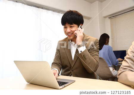 Businessmen having a meeting while talking on a smartphone 127123185