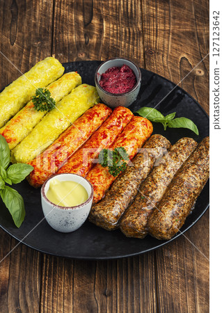 Raw grilled sausages and ingredients cooking. 127123642