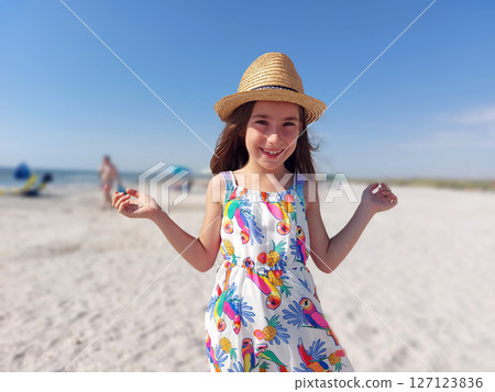 Portrait of adorable young girl on the beach in summer dress and hat Portrait of adorable young girl on the beach in summer dress and hat 127123836