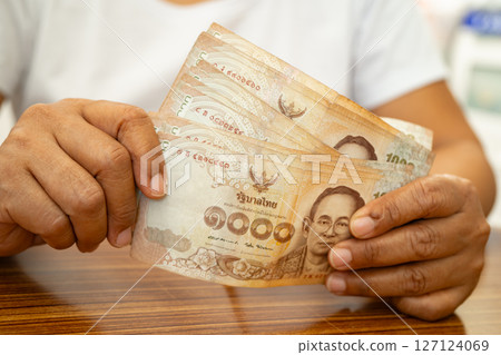 Asian business woman holding Thai banknote currency money. Asian business woman holding Thai banknote currency money. 127124069