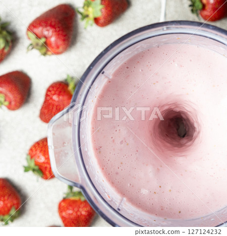The process of making a strawberry milkshake, whisking all the ingredients in a blender. The process of making a strawberry milkshake, whisking all the ingredients in a blender. 127124232