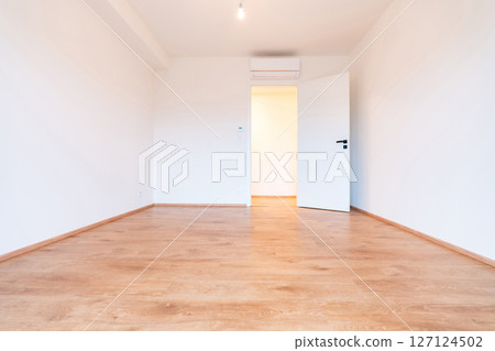 Airy and bright empty apartment room with wooden flooring and clean white walls Airy and bright empty apartment room with wooden flooring and clean white walls 127124502