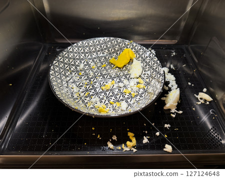 Exploded egg in microwave, cleaning concept and food safety awareness 127124648