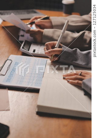 Group of confident business people point to graphs and charts to analyze market data, balance sheet, account, net profit to plan new sales strategies to increase production capacity. Group of confident business people point to graphs and charts to analyze market data, balance sheet, account, net profit to plan new sales strategies to increase production capacity. 127125034