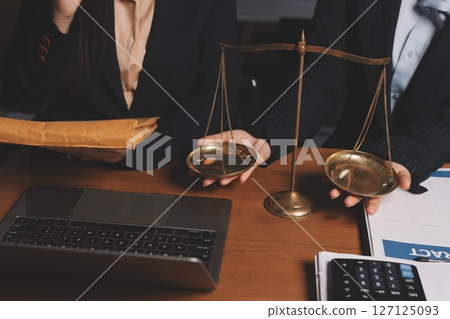Attractive young lawyer in office Business woman and lawyers discussing contract papers with brass scale on wooden desk in office. Law, legal services, advice, Justice and real estate concept. Attractive young lawyer in office Business woman and lawyers discussing contract papers with brass scale on wooden desk in office. Law, legal services, advice, Justice and real estate concept. 127125093