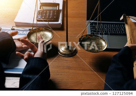 Attractive young lawyer in office Business woman and lawyers discussing contract papers with brass scale on wooden desk in office. Law, legal services, advice, Justice and real estate concept. 127125094