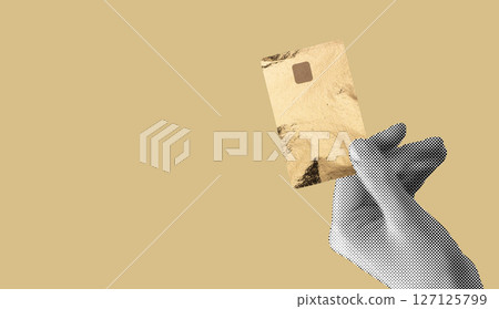 Hand holding a golden credit card with a chip, symbolizing luxury, secure digital payments, and 127125799