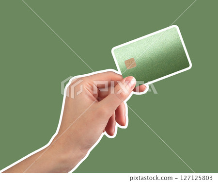 Hand holding a green bank card with chip, symbolizing luxury and secure cashless transactions. 127125803