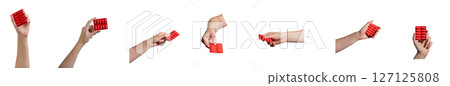 Hand holding a red capsule blister pack, representing medication and healthcare. Isolated on a white Hand holding a red capsule blister pack, representing medication and healthcare. Isolated on a white 127125808