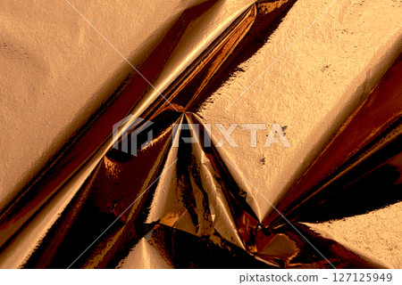 Golden and copper foil texture with a glossy, metallic finish, creating a sleek, modern backdrop. Golden and copper foil texture with a glossy, metallic finish, creating a sleek, modern backdrop. 127125949