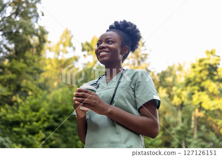 Smiling positive african american burse having coffee in the park 127126151