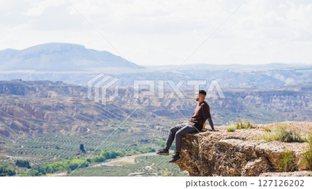 Tourist enjoying the scenic view from a cliff in gorafe, spain 127126202