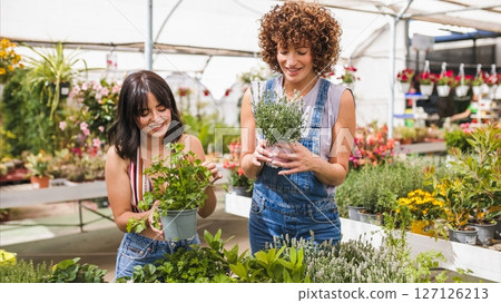 Garden center workers holding aromatic plants in greenhouse Garden center workers holding aromatic plants in greenhouse 127126213