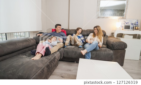 Family relaxing on sofa, enjoying time together 127126319