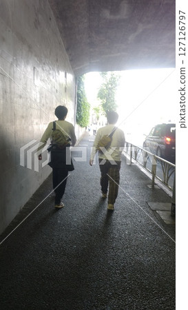 Parent and child walking through a tunnel Parent and child walking through a tunnel 127126797