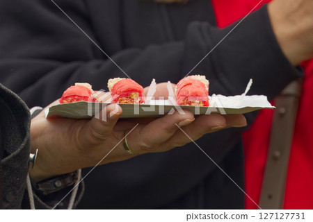 Person Holding a Plate of Appetizing Red Snacks on a Casual Occasion Person Holding a Plate of Appetizing Red Snacks on a Casual Occasion 127127731