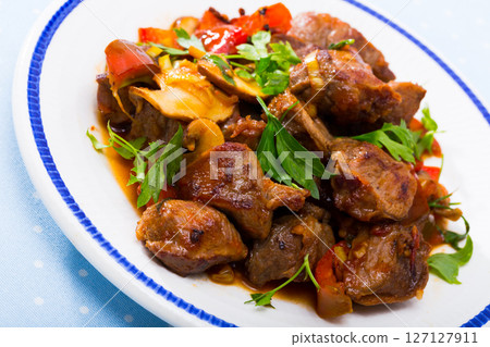 Delicious fried pork with button mushroom, peppers and greens 127127911