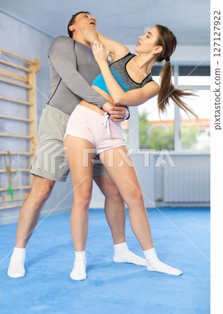 Woman and man practicing self defense techniques 127127922