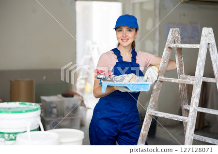 Female painter posing in apartment being renovated Female painter posing in apartment being renovated 127128071