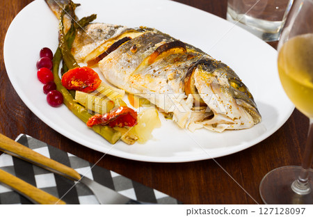 Roasted dorada with baked vegetables and cranberries 127128097