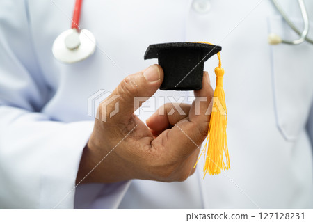 Asian woman doctor holding graduation hat in hospital, Medical education. 127128231