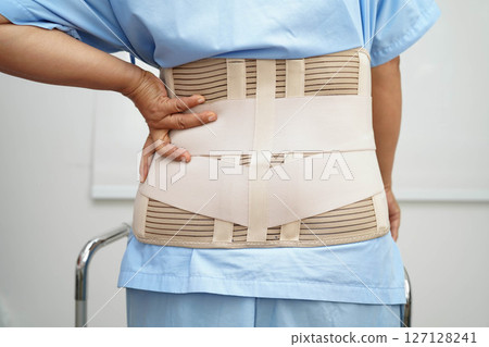 Asian woman wearing lumbar support pain back and use walker in hospital. Asian woman wearing lumbar support pain back and use walker in hospital. 127128241