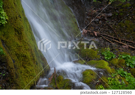 Waterfall cascading down rock face Waterfall cascading down rock face 127128560