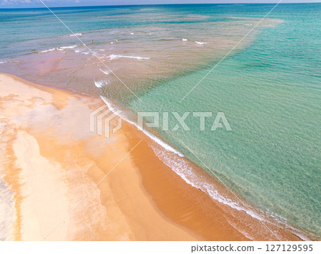 Top view beach with waves crashing on sandy shore,Beautiful waves sea surface in summer seascape background,Amazing beach colorful water background Top view beach with waves crashing on sandy shore,Beautiful waves sea surface in summer seascape background,Amazing beach colorful water background 127129595