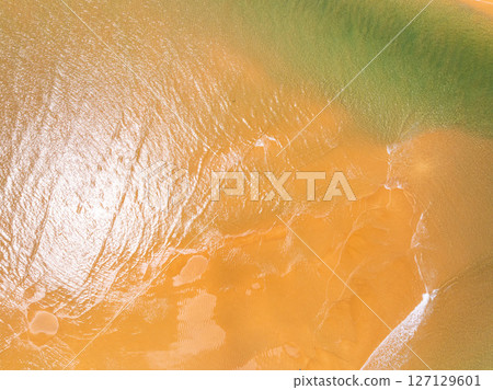 Top view beach with waves crashing on sandy shore,Beautiful waves sea surface in summer seascape background,Amazing beach colorful water background 127129601